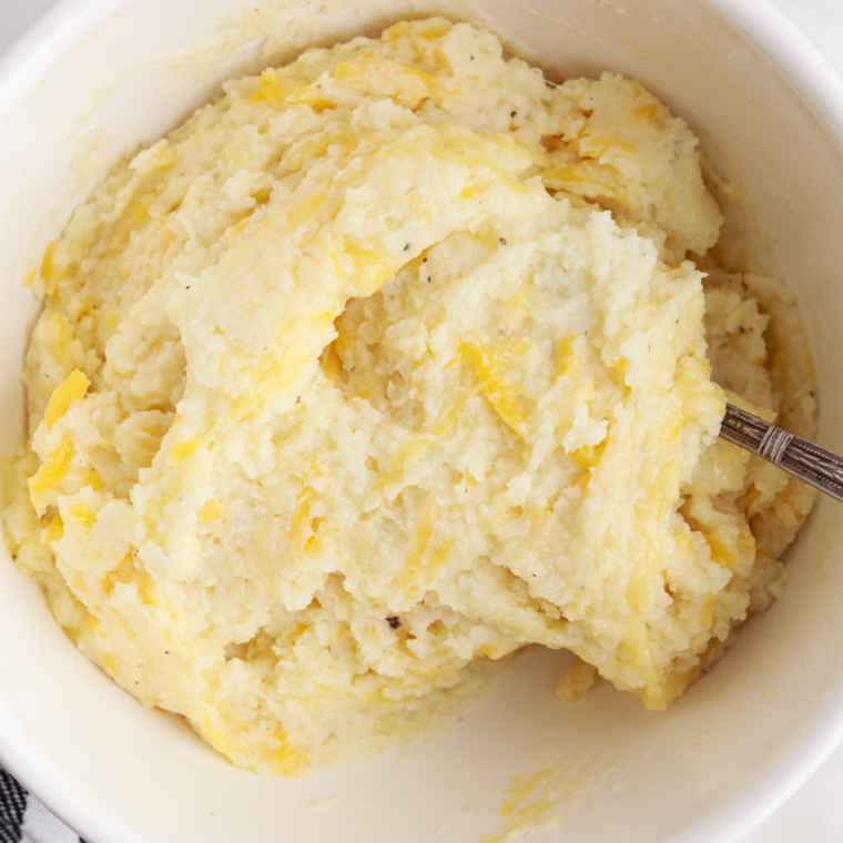 Warm milk and cream being poured into creamy mashed potatoes in the Instant Pot