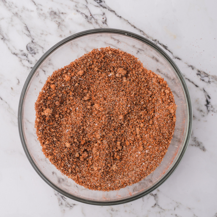 Cajun seasoning poured into a glass spice jar for storage