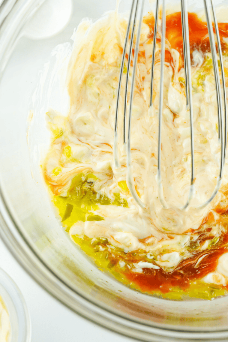 Mayonnaise, barbecue sauce, ketchup, mustard, relish, and Worcestershire sauce in a bowl for copycat Diner Q sauce