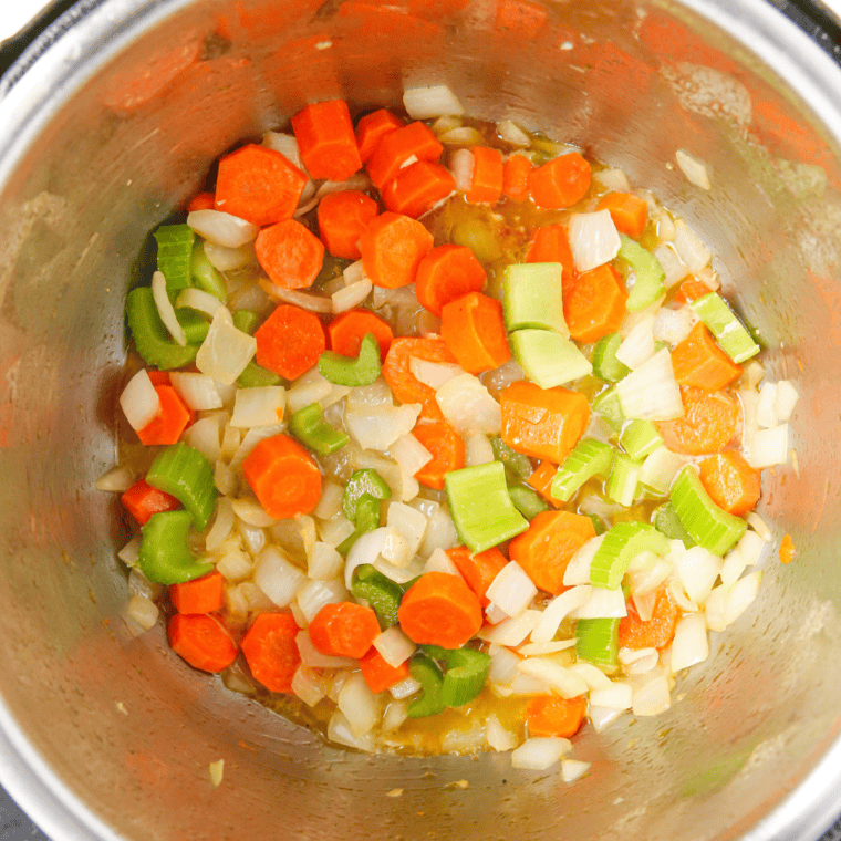 Vegetables sautéing in an Instant Pot for pressure cooker chicken noodle soup