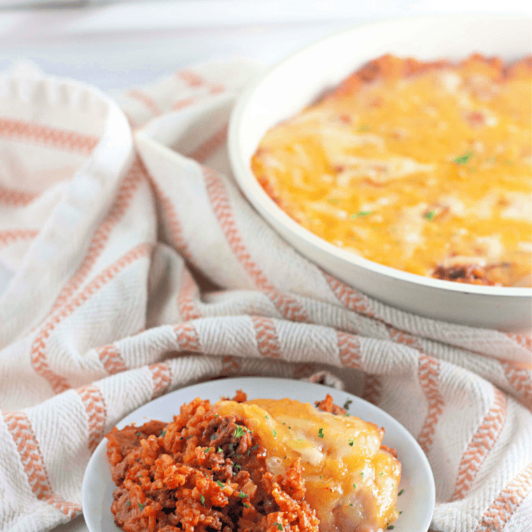 Taco rice skillet with a serving spoon lifting cheesy beef and rice from the pan