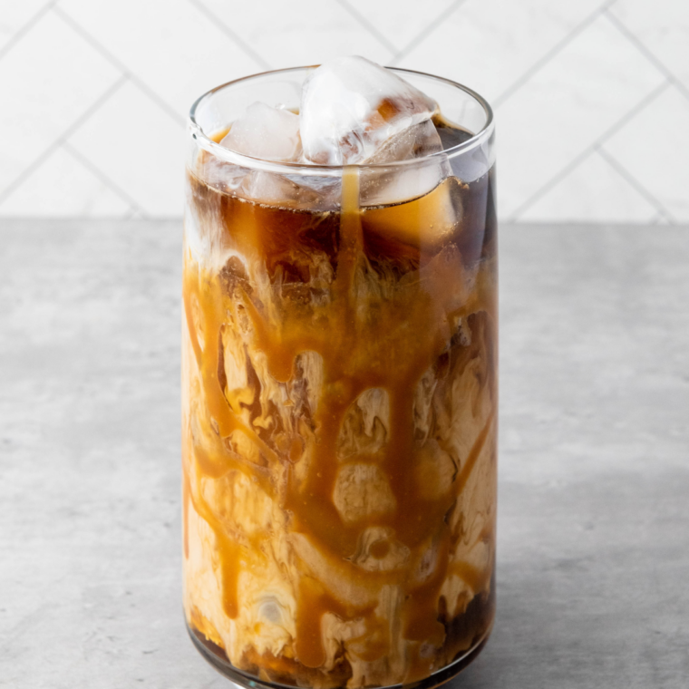 Viral Buc-ee's iced coffee in a tall glass with chocolate and caramel drizzle and swirls of vanilla creamer