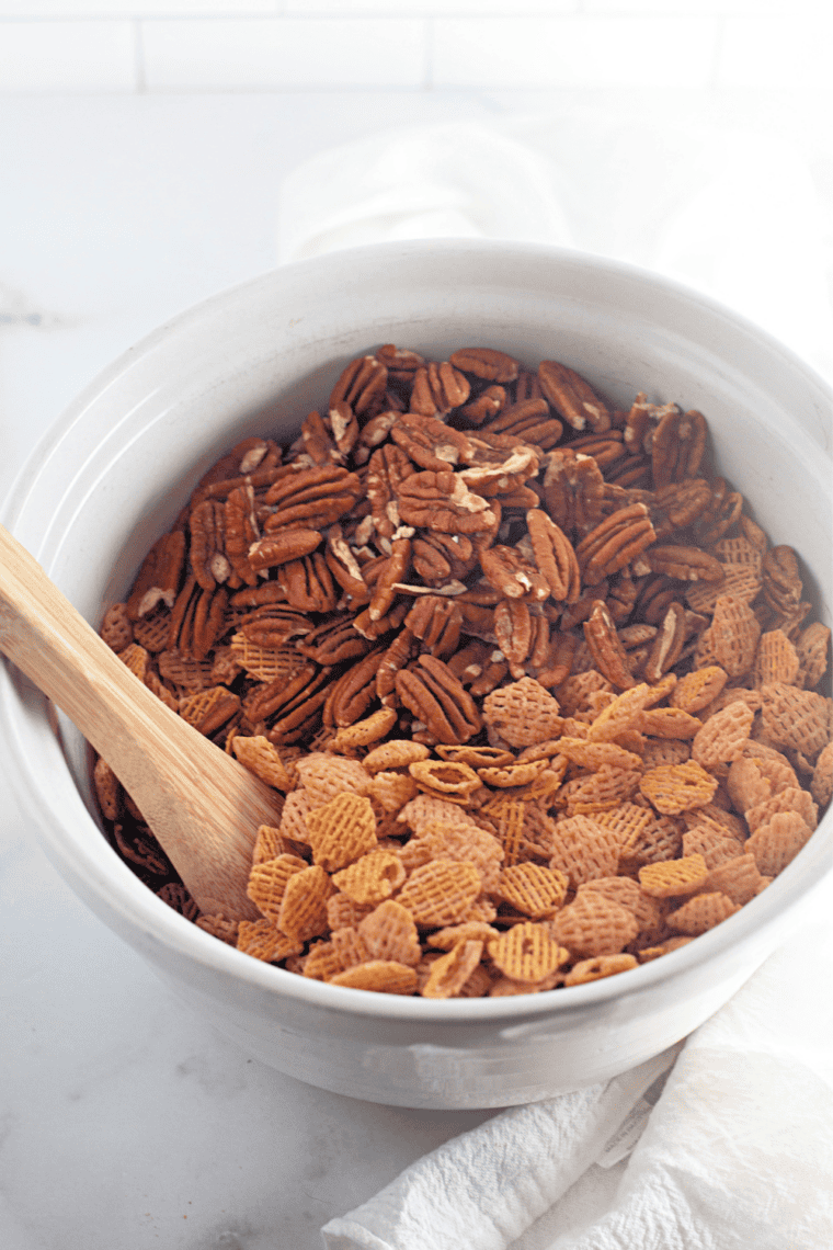 Combine the dry ingredients: Crispix cereal and pecan halves tossed together in a large mixing bowl