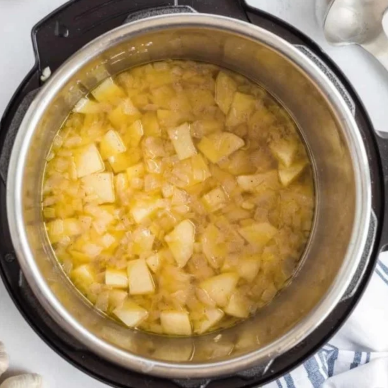 Diced potatoes simmering in clam juice in a Dutch oven