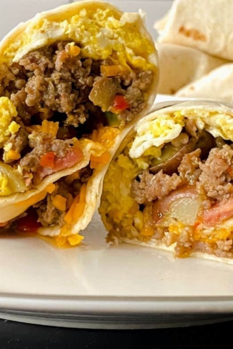 Stack of homemade sausage and bacon breakfast burritos with salsa on the side