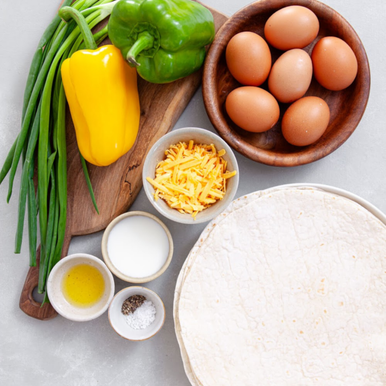 Ingredients for copycat Buc-ee's breakfast burritos including flour tortillas, eggs, sausage, bacon, and shredded cheddar cheese