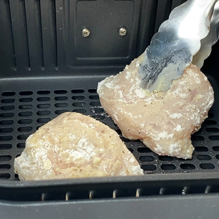 Golden, crispy breaded chicken cutlets in a single layer in the air fryer basket