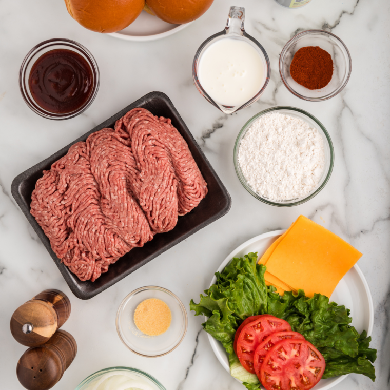 ingredients for homemade Western Bacon Cheeseburger: ground beef, bacon, American cheese, onion, sesame buns, and BBQ sauce ingredients