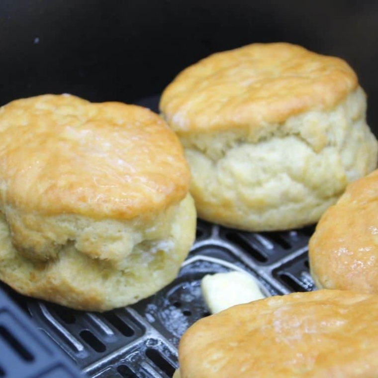 1. Step 4: Homemade Hardee's biscuits in an air fryer basket brushed with melted butter