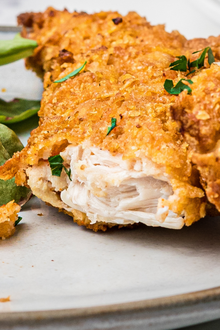 Close-up of a crispy copycat Hardee&rsquo;s chicken tender dipped in honey mustard
