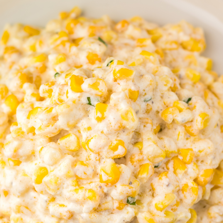 Serving of Lawry's-style creamed corn on a white plate, ready to enjoy as a holiday side dish.