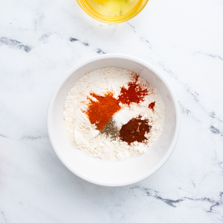 Seasoned flour, cornstarch, and spices whisked together in a bowl for boneless wings.