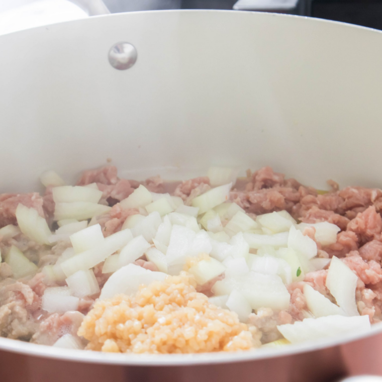 Finely textured ground beef simmering in broth for coney-style Sonic chili