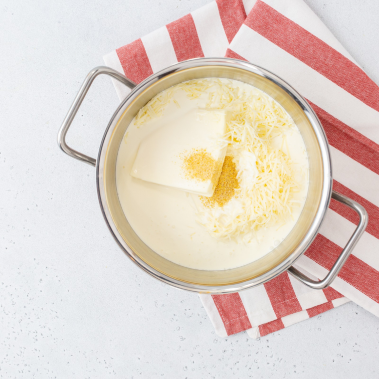 Whisking butter and flour together in a saucepan to make a roux