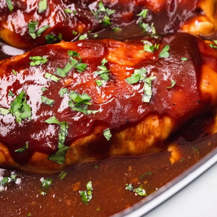 Slow cooker BBQ chicken breast plated with creamy coleslaw and a wedge of skillet cornbread