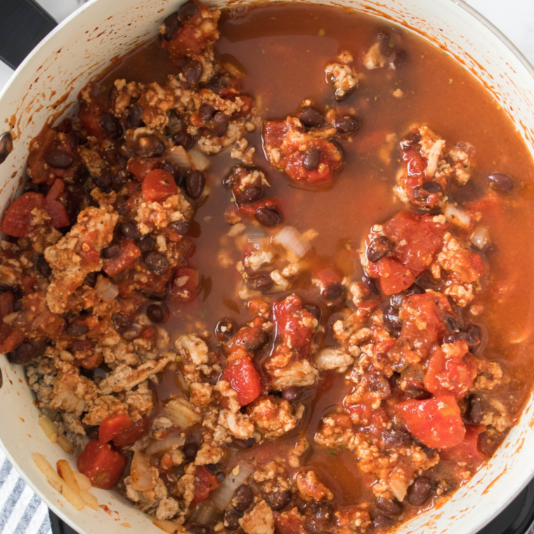 Tomato sauce, tomato paste and spices stirred into cooked ground beef