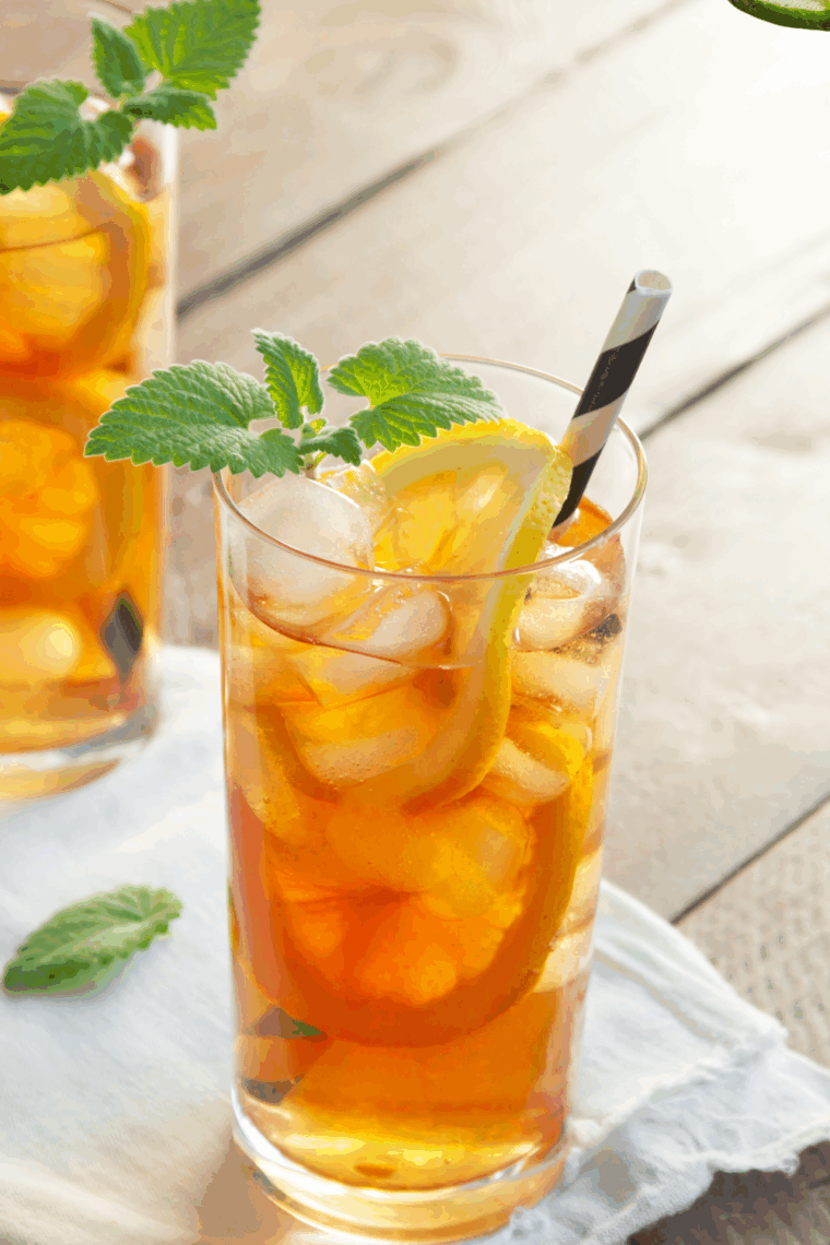 Glass of homemade McDonald’s Sweet Tea copycat recipe served over ice with lemon.