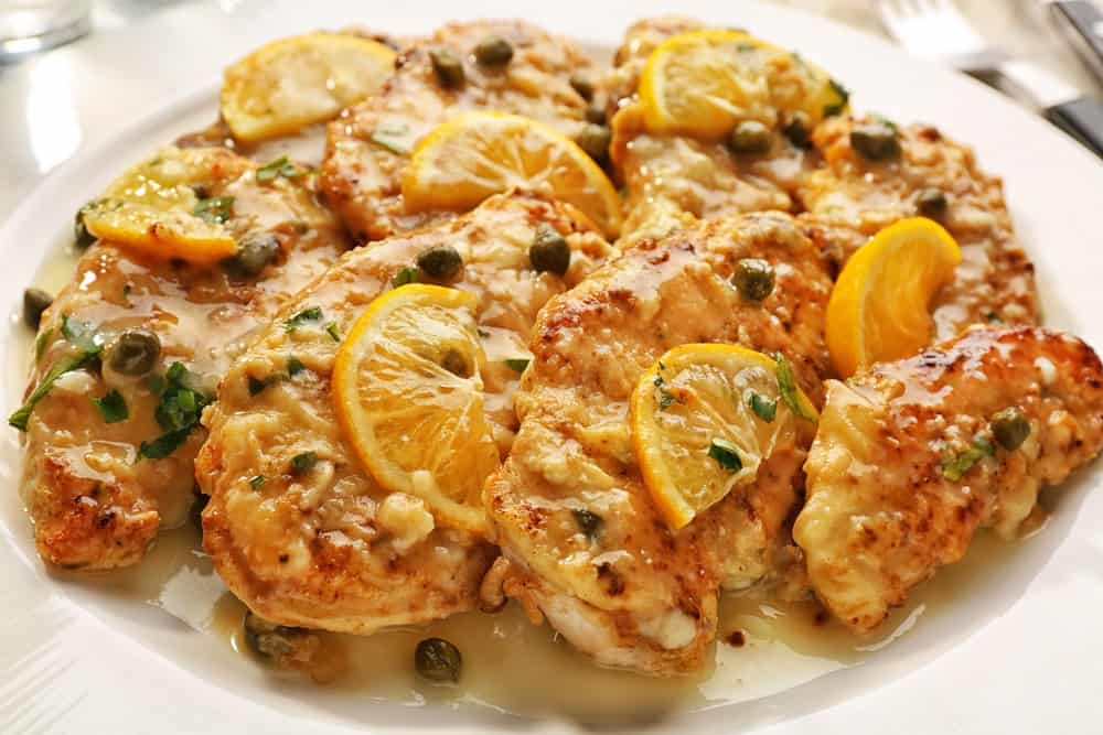 The dish known as chicken piccata is a relatively simple one, but packs a lot of flavor. Chicken breasts are thinly sliced and sautéed until cooked through. They're then simmered in a sauce made with white wine, lemon juice, capers, and butter. The end result is a tangy, salty, and creamy dish that's sure to please. Serve chicken piccata with rice or pasta for a complete meal.