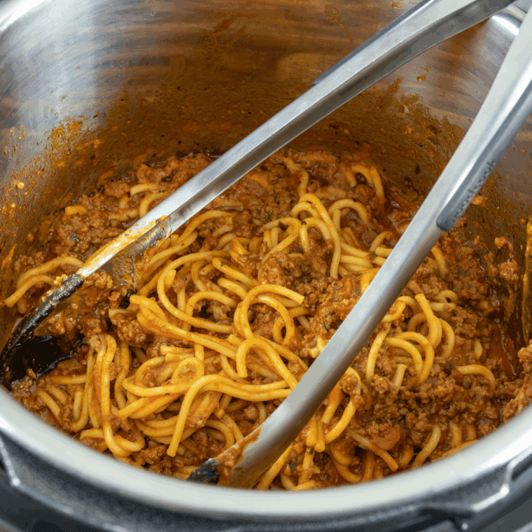 Meat sauce stirred, garnished with fresh basil or parsley, served over pasta.