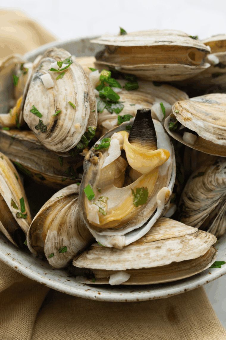 Tender steamed clams cooked in the Instant Pot with garlic, butter, and white wine, served in a bowl ready to eat.