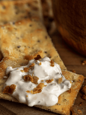 A bowl of creamy New England Bean Dip served with fresh veggies and crispy tortilla chips.