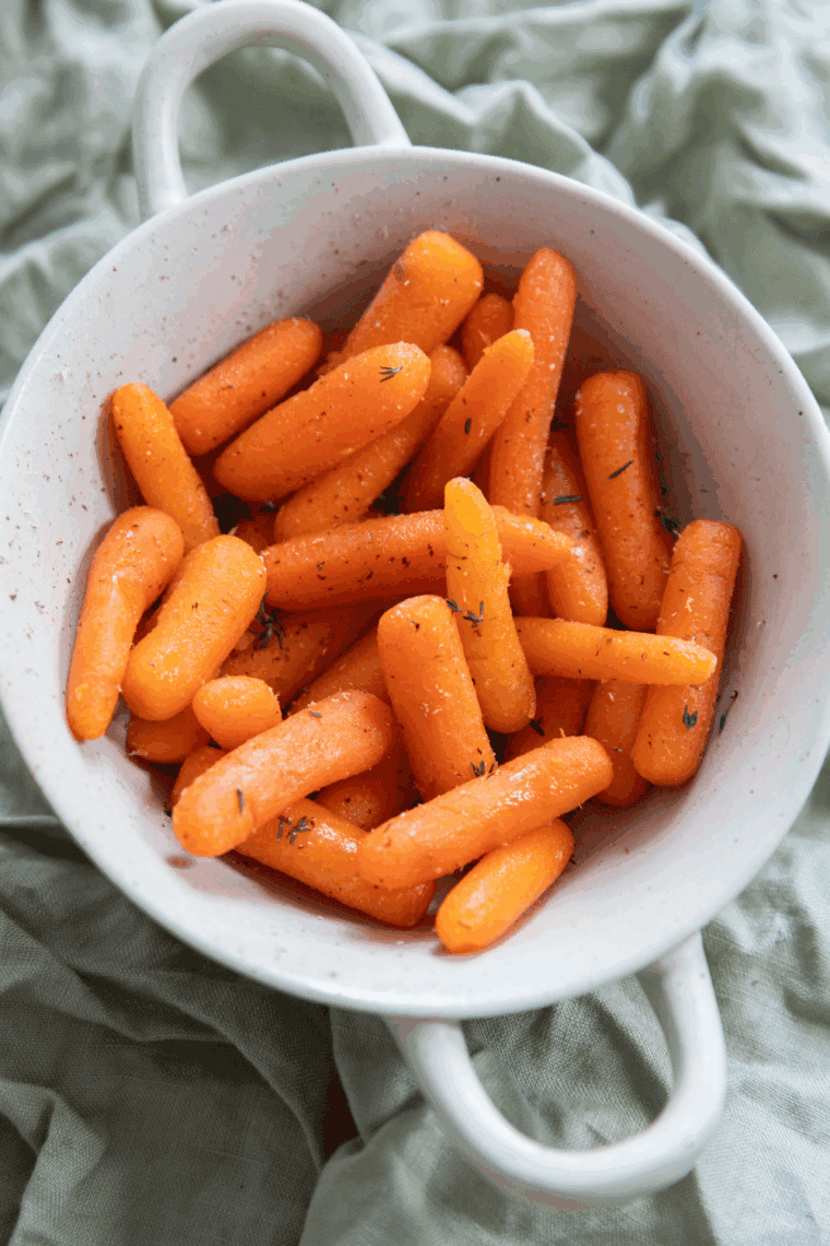 Bowl of sweet, buttery, tender Copycat Cheddar’s Carrots garnished with parsley.