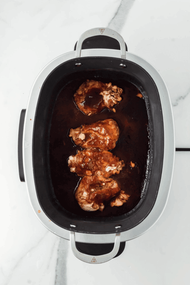 Slow cooker covered, cooking chicken on low or high until tender and shreddable.