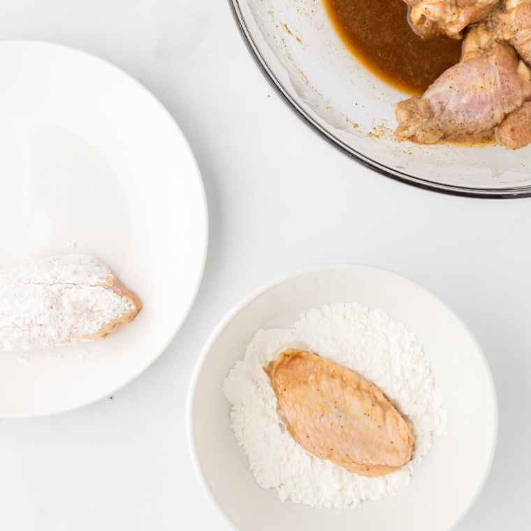 Coating the chicken wings with baking powder and cornstarch.