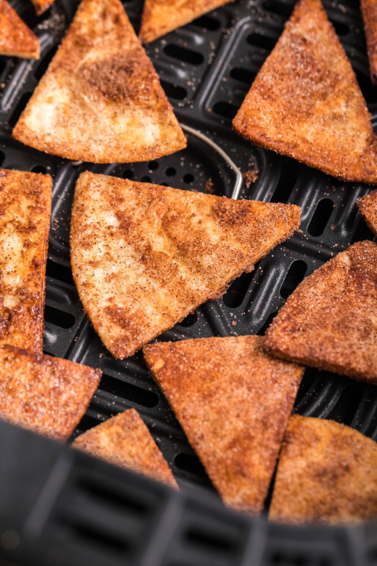 A plate of crispy air fryer cinnamon tortilla chips dusted with sweet cinnamon sugar.