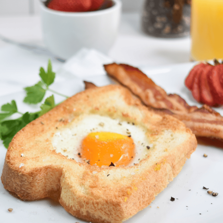 Air fryer egg in a hole with crispy golden toast and a sunny-side-up egg in the center.