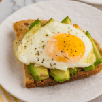 Perfectly cooked air fryer fried eggs with crispy edges and soft yolks."