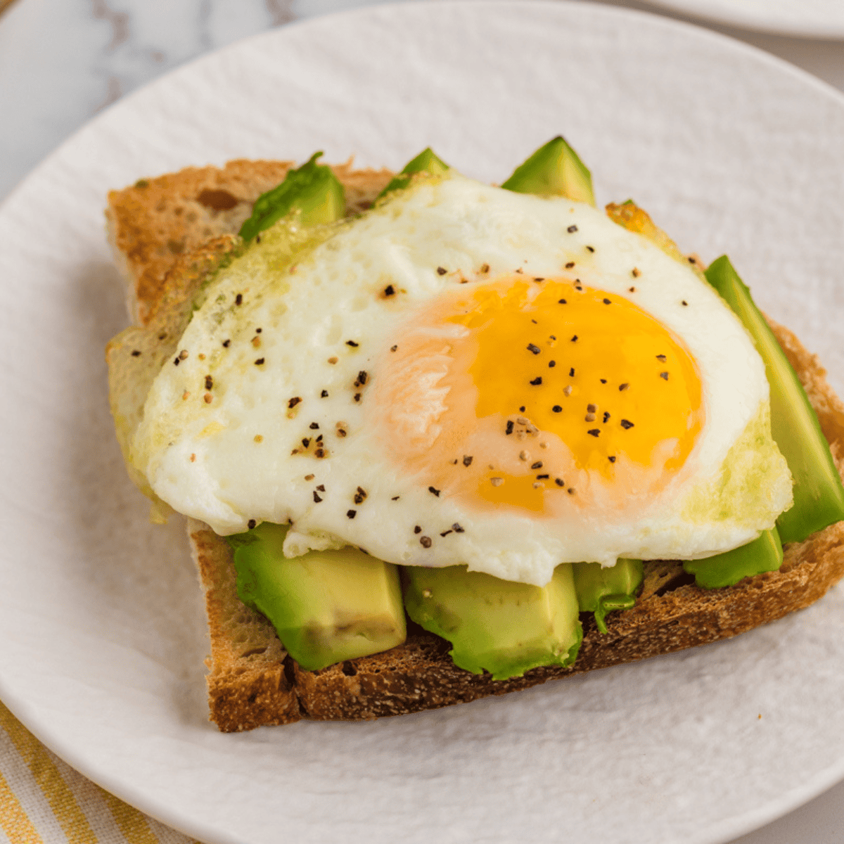 Perfectly cooked air fryer fried eggs with crispy edges and soft yolks.