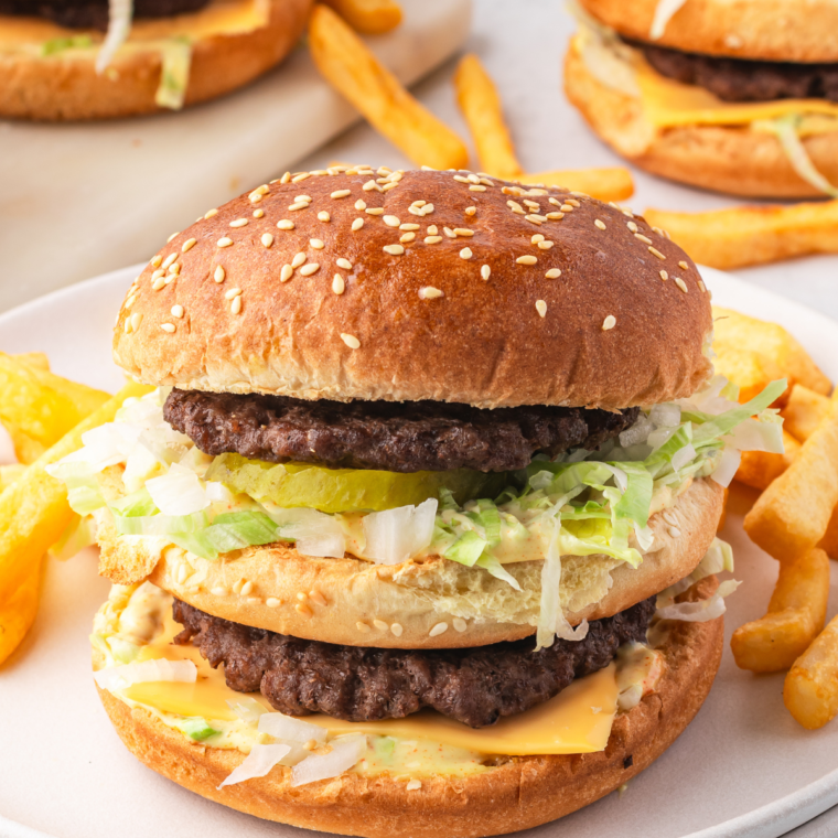 Homemade Big Mac with special sauce, seasoned beef patties, lettuce, pickles, onions, and sesame seed buns.