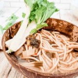 Bowl of steaming Instant Pot miso soup with tofu cubes, seaweed, and chopped green onions.