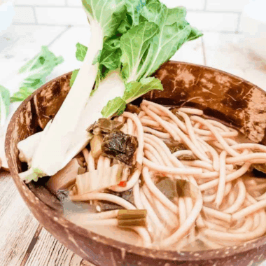 Bowl of steaming Instant Pot miso soup with tofu cubes, seaweed, and chopped green onions.