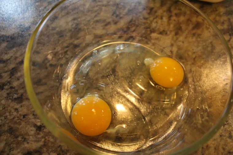 overhead process shot: two eggs in a bowl to make french toast in air fryer