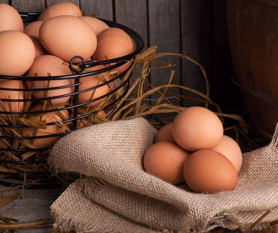 a basket of fresh eggs with three on a burlap cloth for fried egg in air fryer