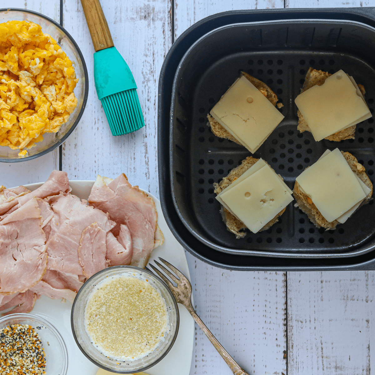 ham and cheese sliders in an air fryer basket.