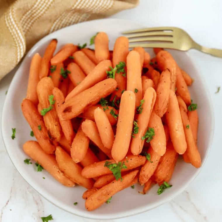 overhead closeup: a plate of air fryer honey carrots with a fork to the side