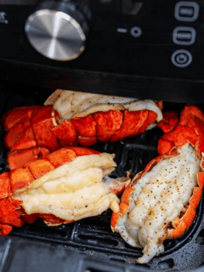 Air fryer lobster tails brushed with lemon garlic butter on a serving plate