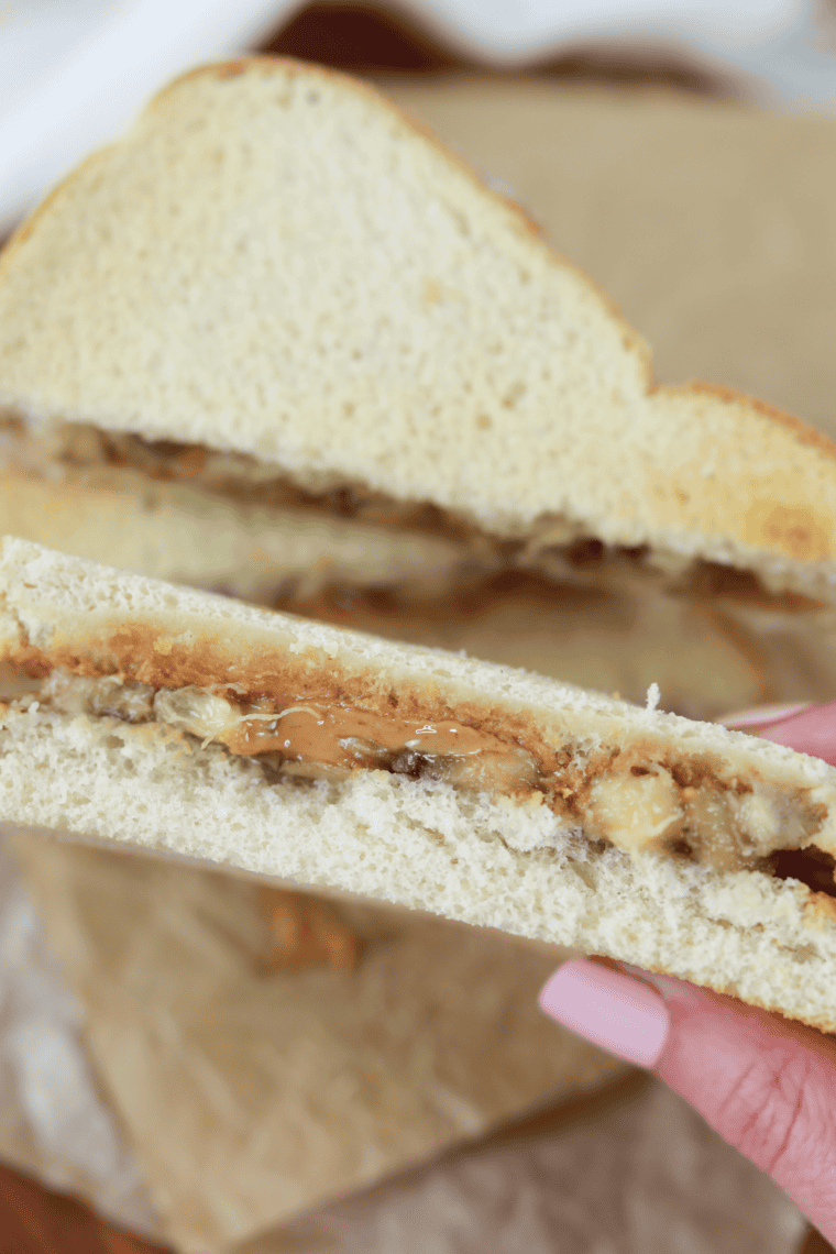Golden crispy air fryer peanut butter banana sandwich with melted peanut butter and warm banana slices inside.