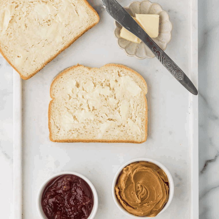 Spread butter onto the bread, to help it toast in the air fryer.
