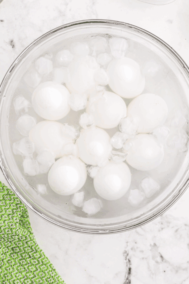 Transfer cooked eggs to an ice water bath to cool quickly and make peeling easier.