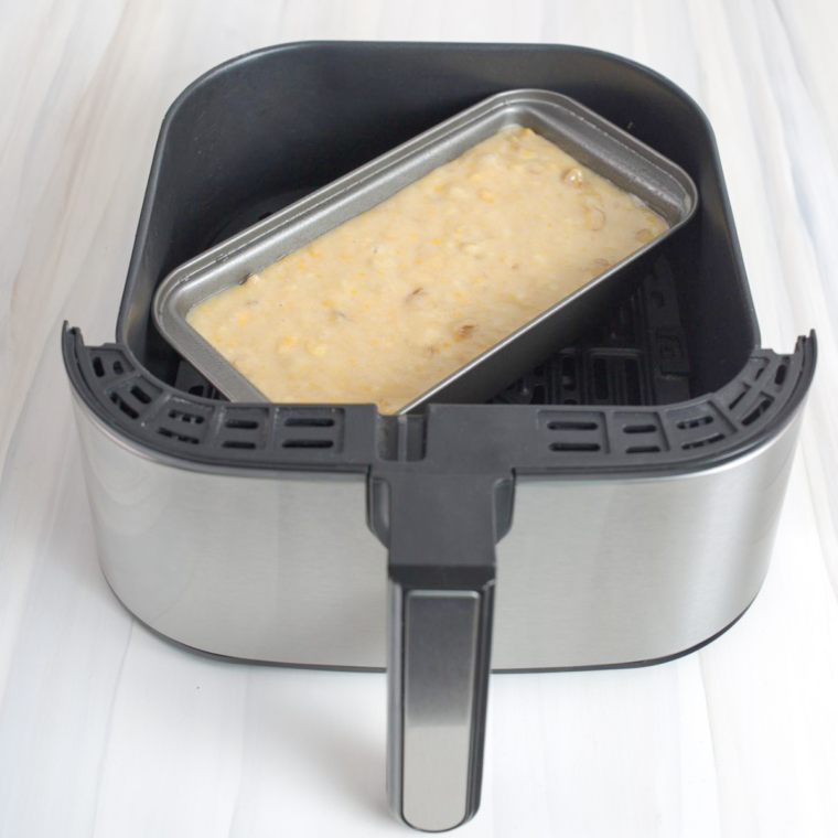 Banana bread baking in loaf pan inside air fryer basket