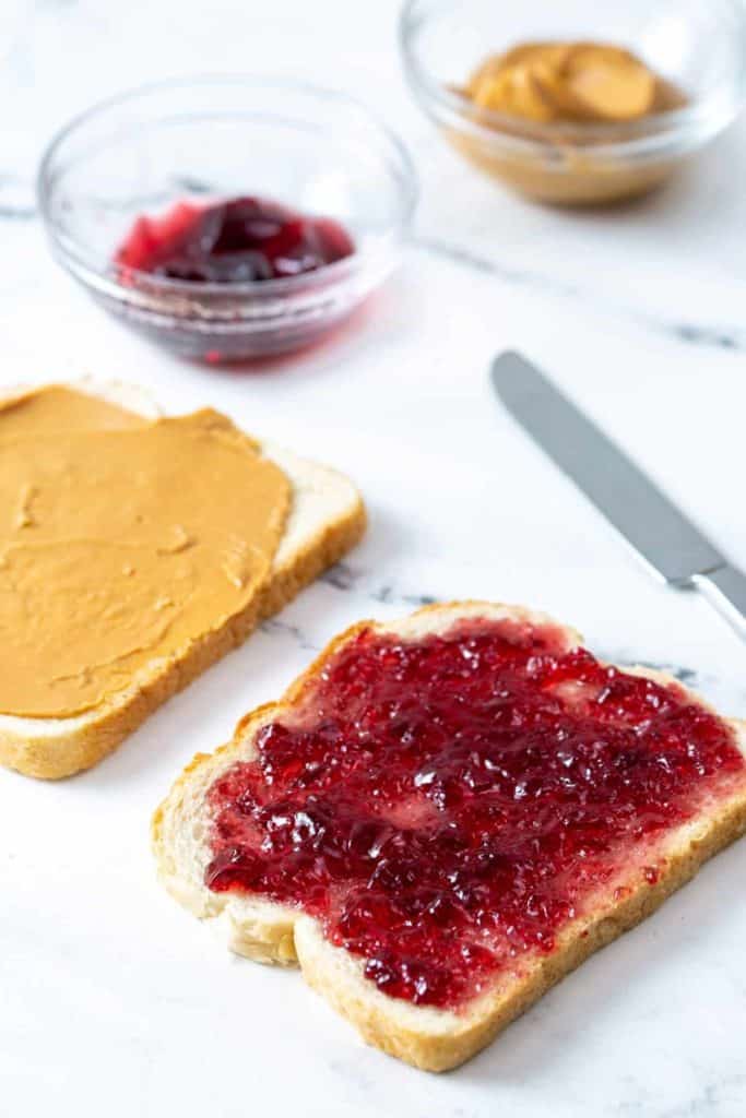 spreading jelly on bread