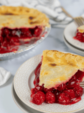 "Golden, flaky whole cherry pie made in the air fryer, topped with a lattice crust and filled with sweet cherry filling."