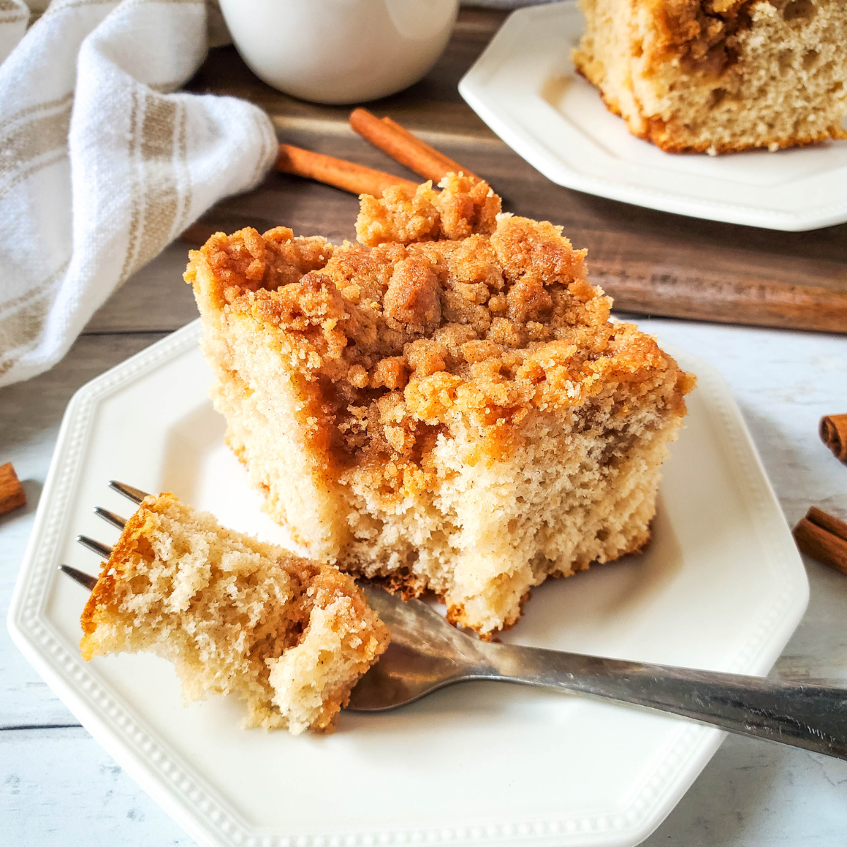 Air fryer coffee cake sliced and served with a cup of coffee.