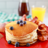 Fluffy air fryer pancakes stacked with butter and syrup on top