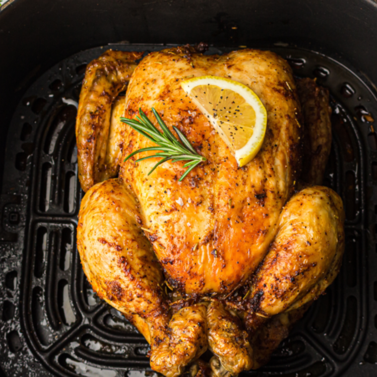 Plated air fryer whole chicken with lemon and thyme, served with roasted vegetables.