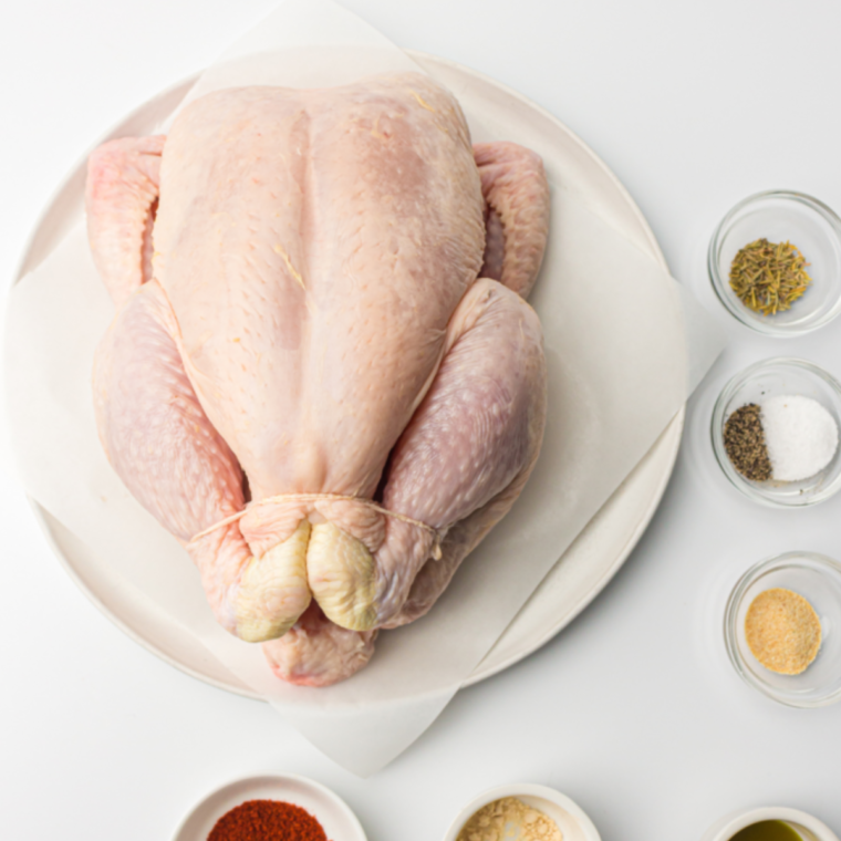 Ingredients for Air Fryer Whole Chicken with Lemon and Thyme on a kitchen table.